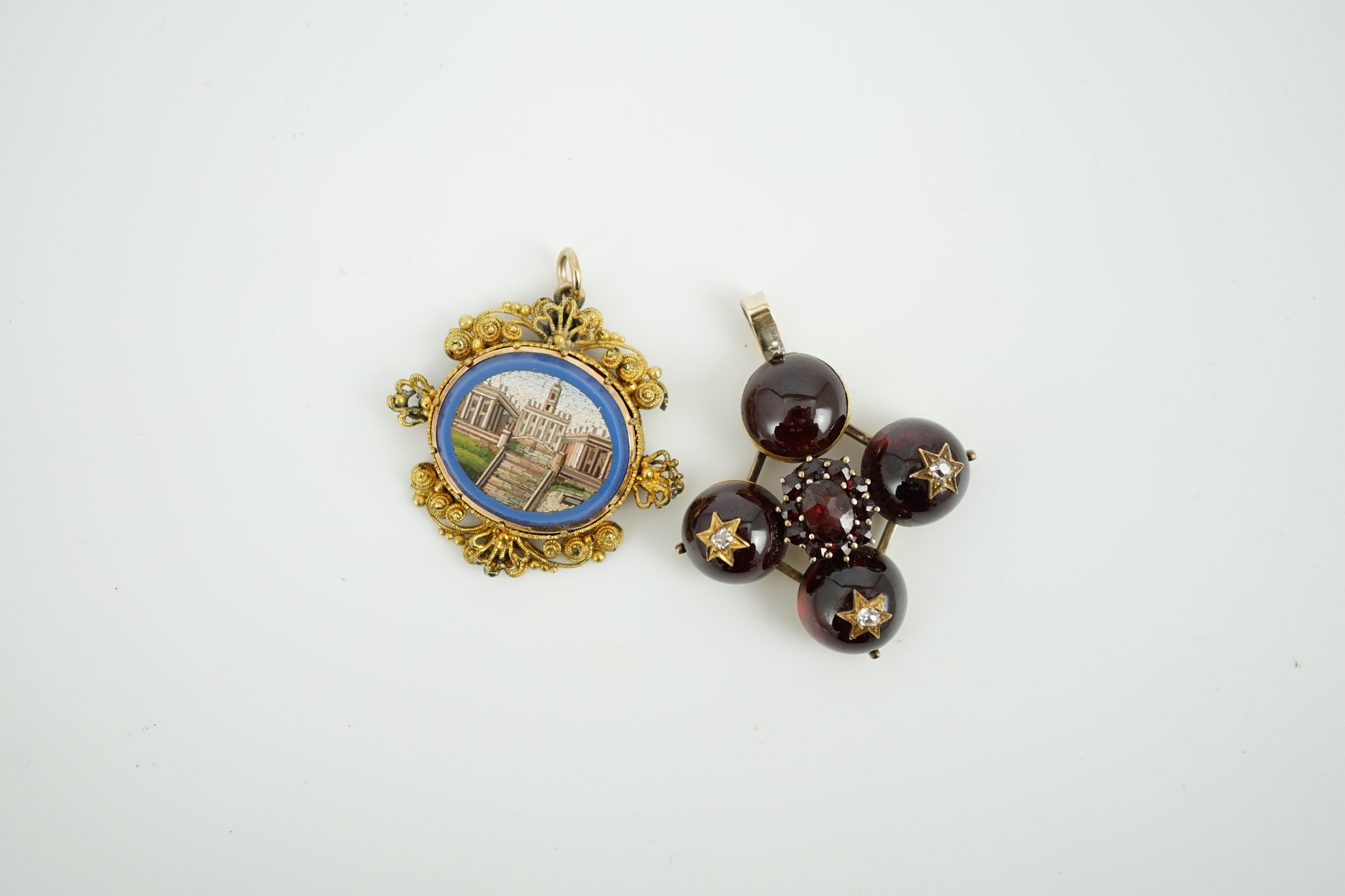 A 19th century gilt metal mounted micro mosaic pendant, 32mm, together with a similar cabochon garnet and diamond set quatrefoil pendant.